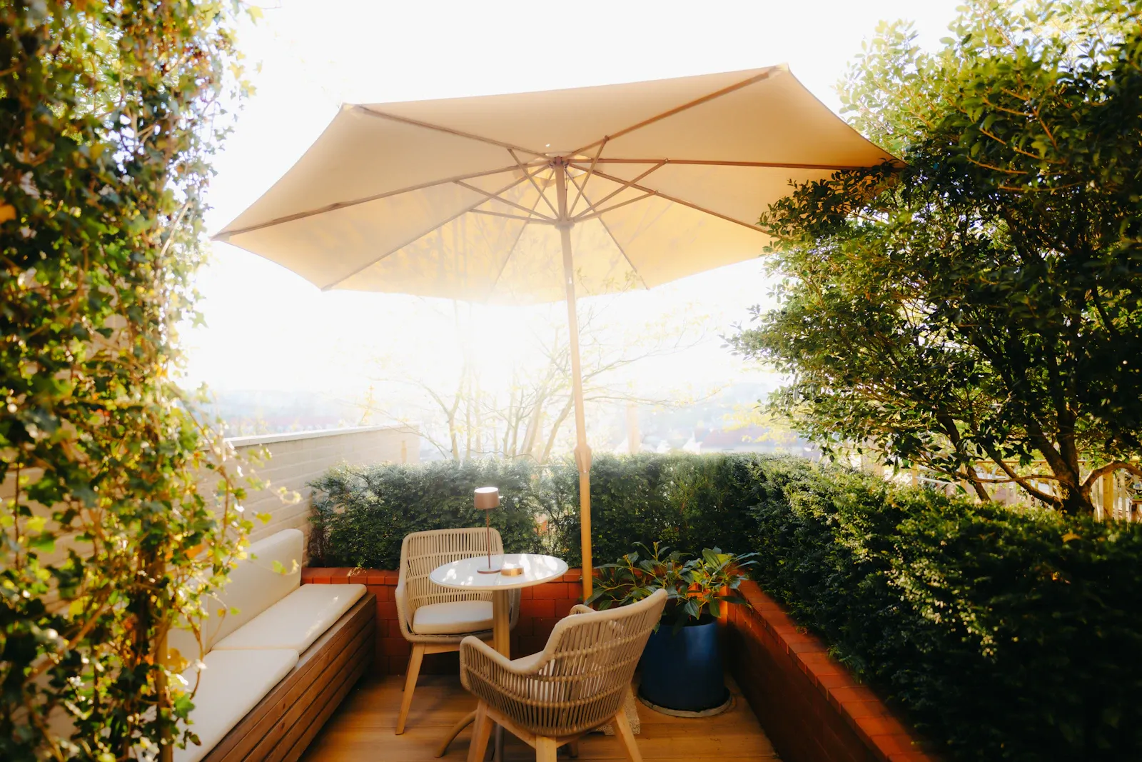 An outdoor patio seating area with an umbrella and plants